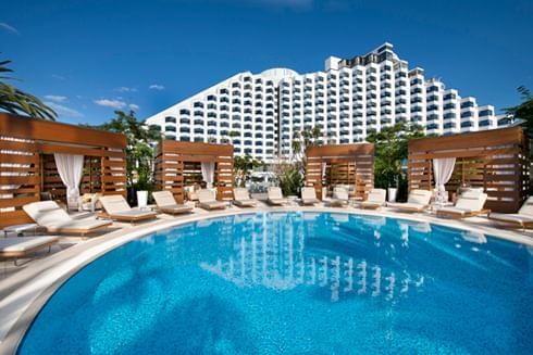Exterior view of Crown Metropol Perth and the outdoor pool area with sunbeds