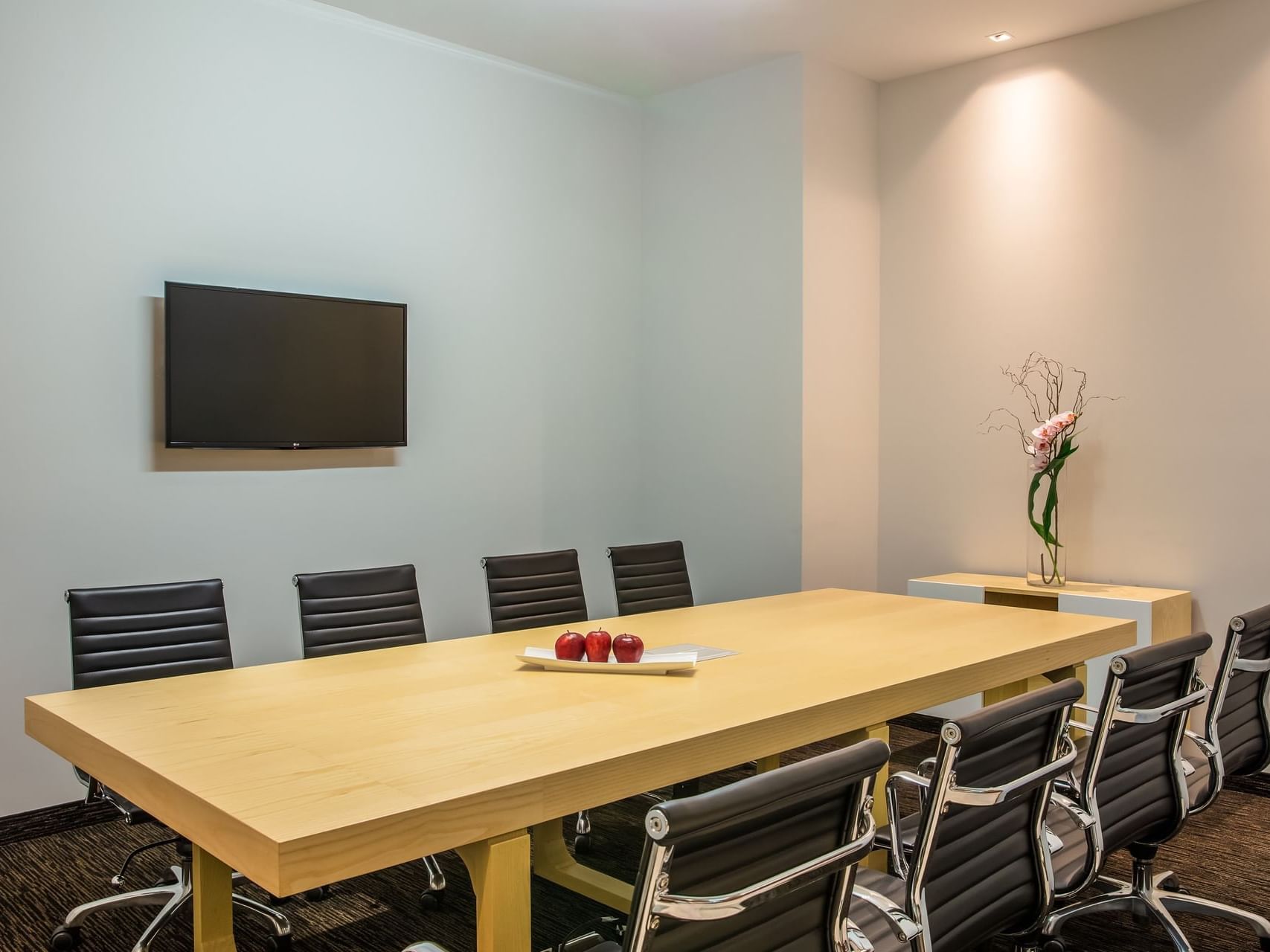 Conference table & a wall Tv in a Business Centre at Fiesta Inn