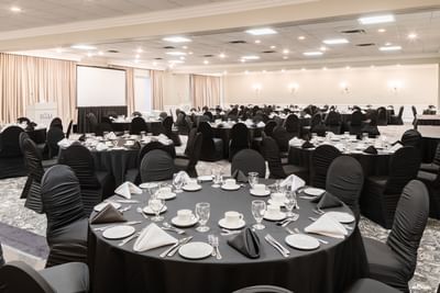 Black tablecloths on round tables under recessed lights at Rodd Charlottetown Hotel, a top-rated rodd Charlottetown