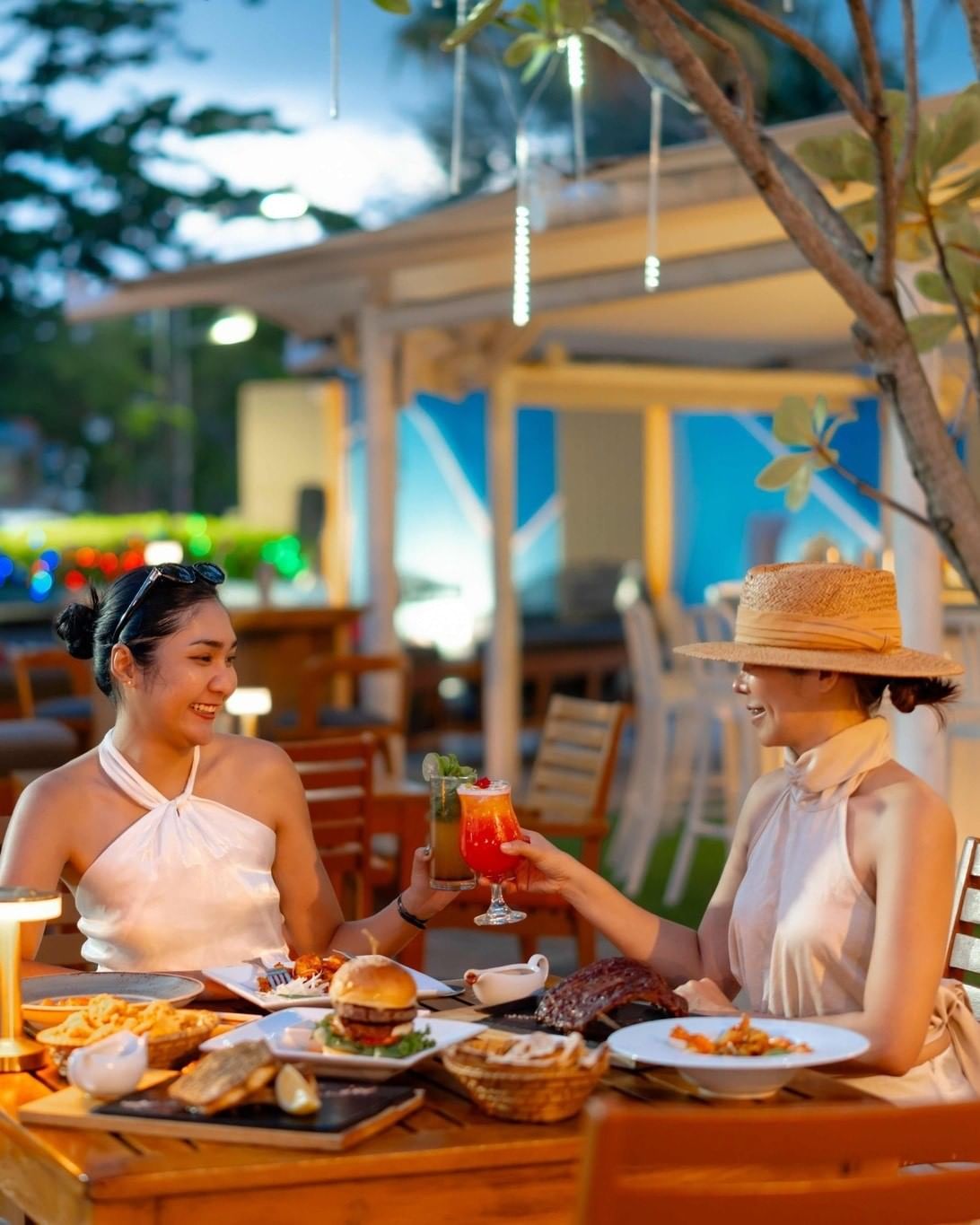 2 women are having dinner at MINT, enjoying live music and tasty food and drinks.