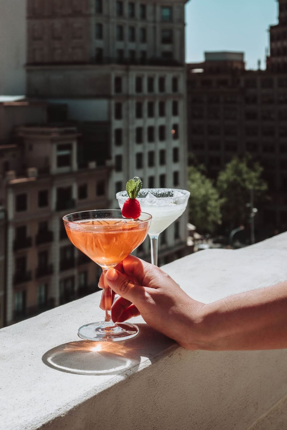 Nahaufnahme einer Hand mit einem Cocktailglas, Almanac X Alcron Prag