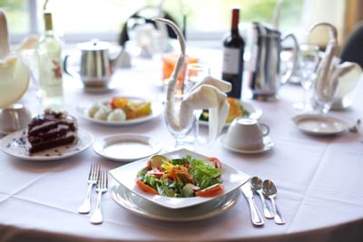 Dining table with food and wine bottle at Honor’s Haven Retreat