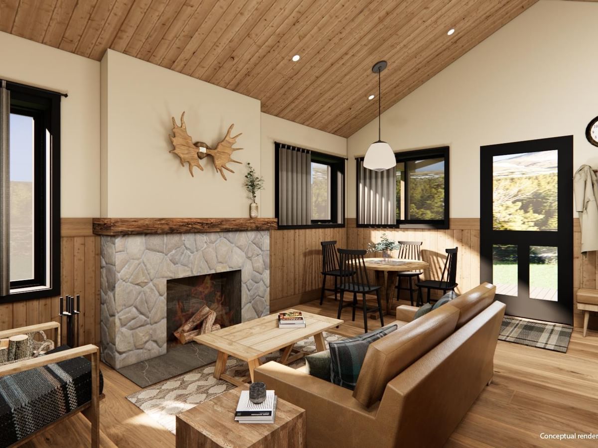 Whistler Cabin interior with fireplace, wood ceiling, sofa, and dining area.