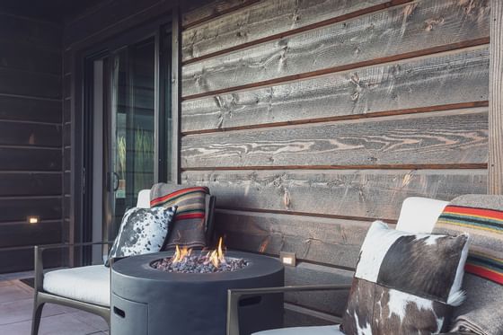 Terrace lounge area with a fire in Colter Suite, Hotel Jackson