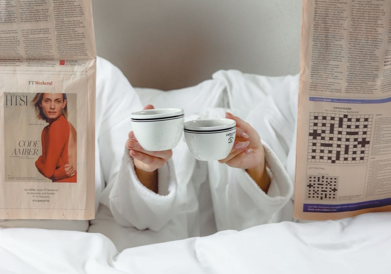 Two persons reading a newspaper while having morning tea at The Londoner