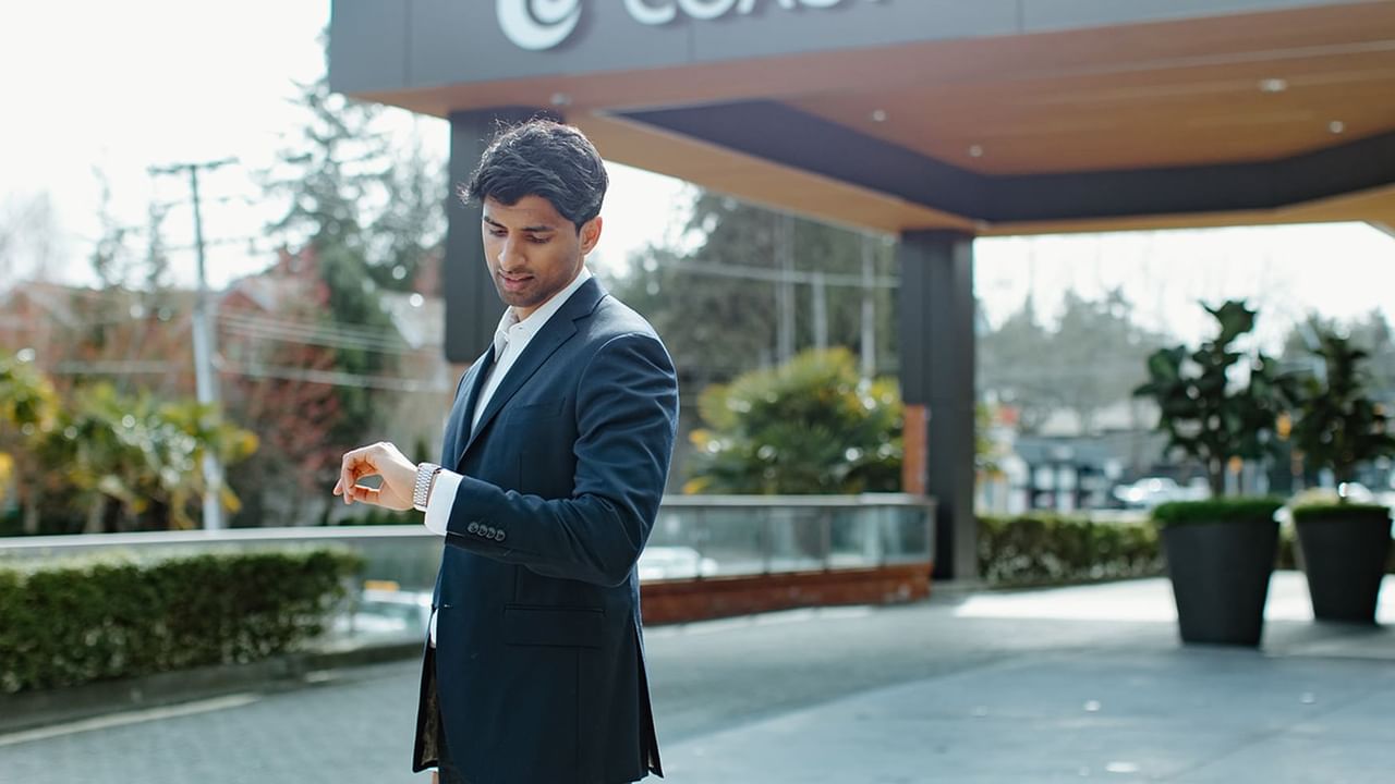 man looking at his watch outside the Coast Tsawwassen Inn