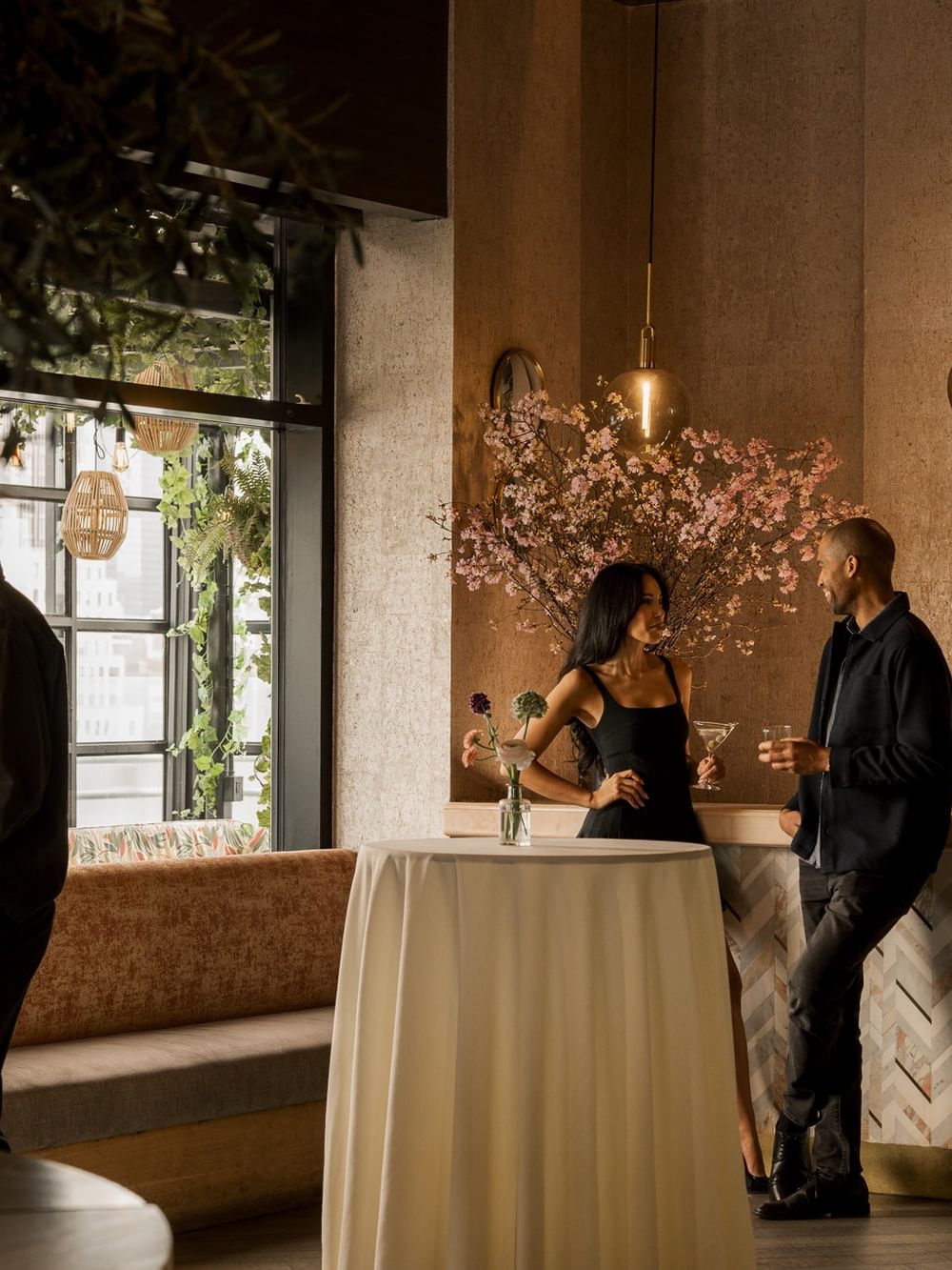 Guests mingling at cocktail tables with floral arrangements in The Loft at Gansevoort Meatpacking, a best meeting space nyc