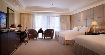 Seating area, TV & work desk by the beds in Premier Room at York Hotel Singapore