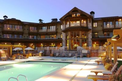 Exterior view of Hotel Park City Autograph Collection featuring outdoor pool surrounded by lounge chairs