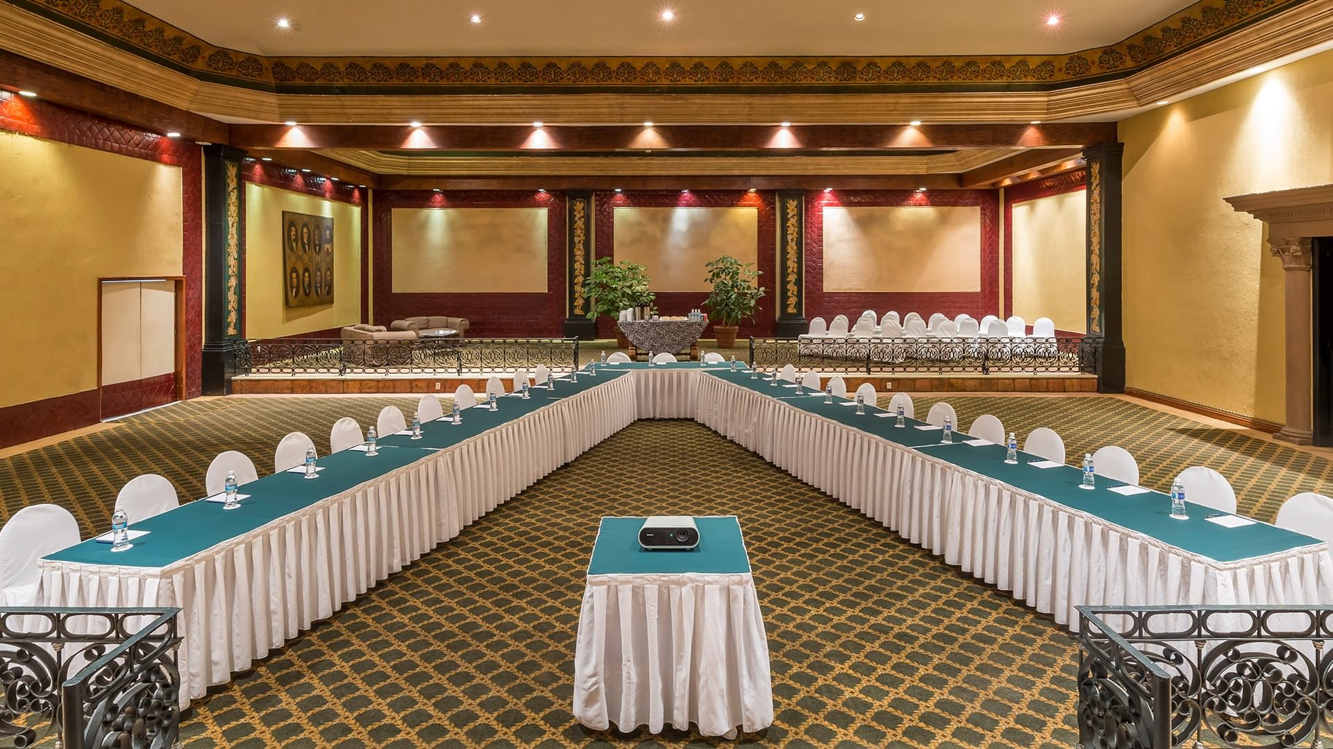 Salón San Marcos featuring a projector, white chairs, and a patterned rug at Quinta Real Aguascalientes