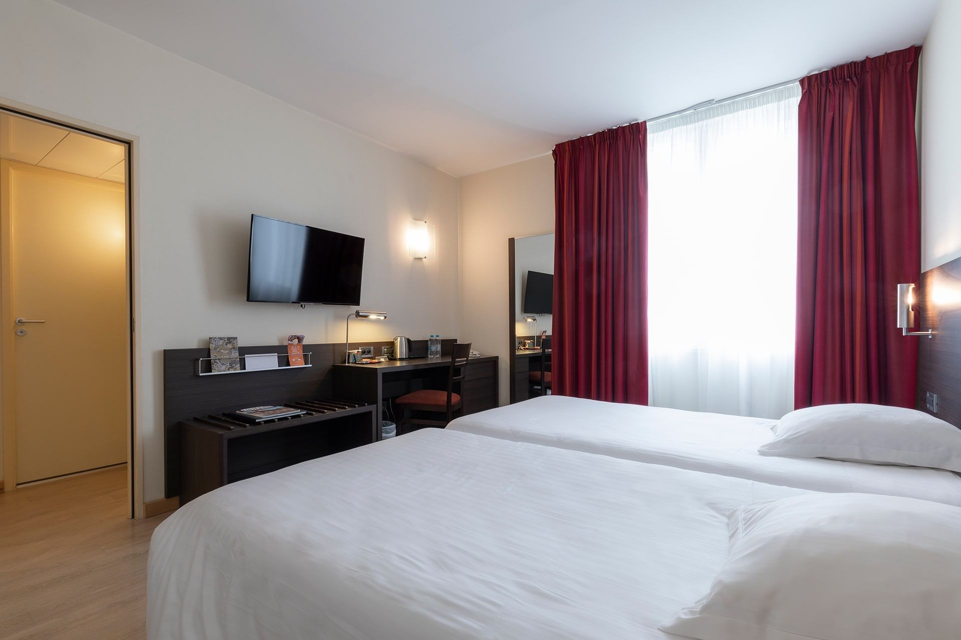 Lit jumeau, télévision et bureau dans une chambre confort à Oceania Brest Centre