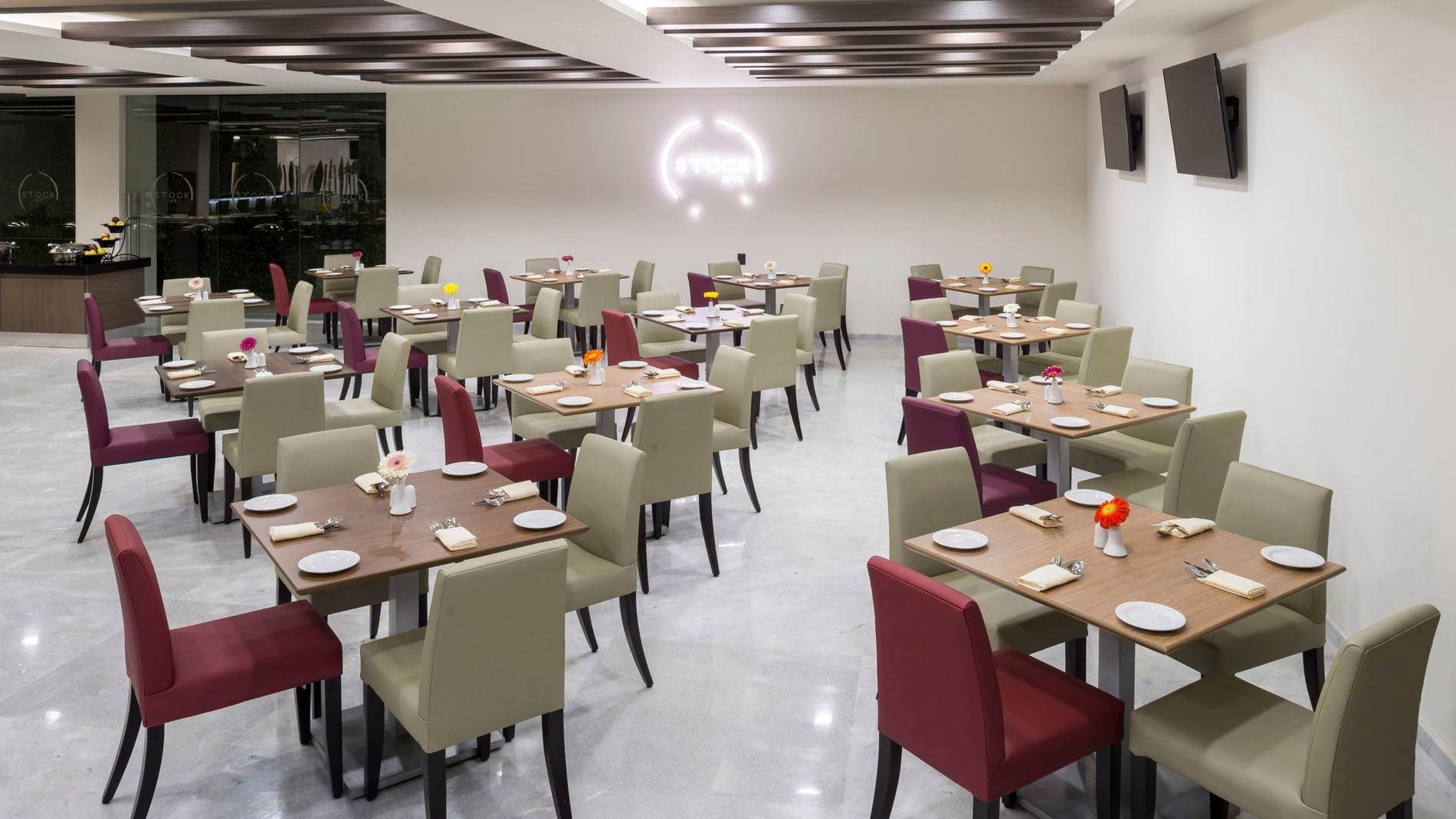Stock Café dining room with neatly set tables, soft lighting, and a spacious layout at Real Inn Celaya