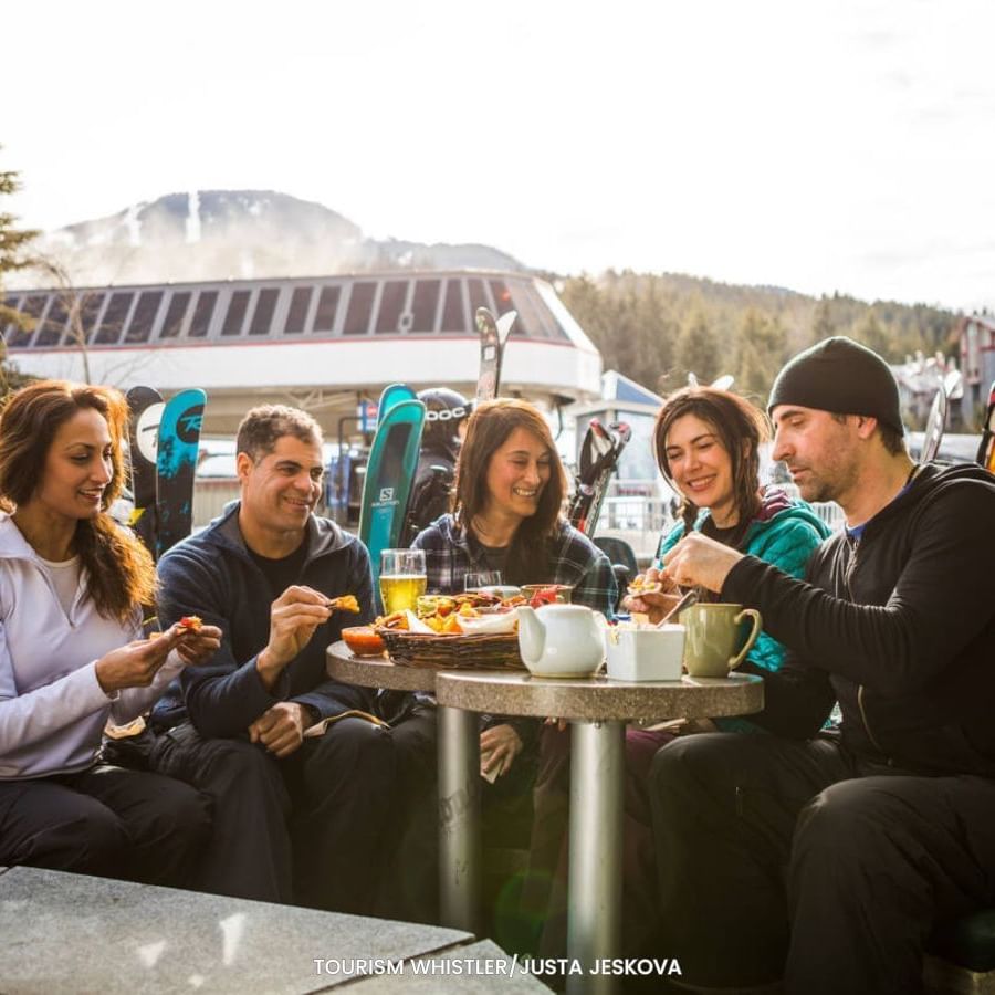 Group of friends dining outdoors near Blackcomb Springs Suites