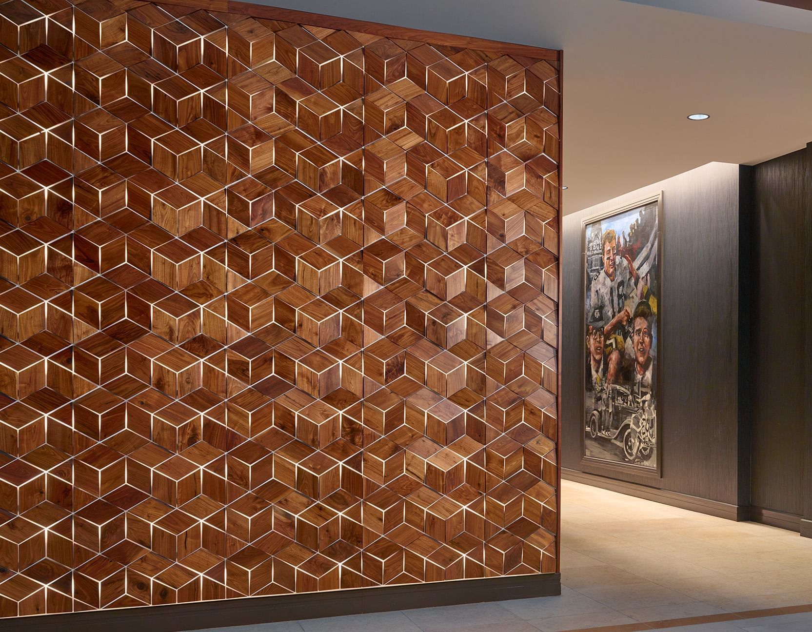 A geometric patterned wall with artwork and lighting