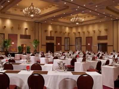 Elegantly decorated meeting hall at Hilton Santa Fe Buffalo Thunder with long tables, chairs, and lavish chandeliers