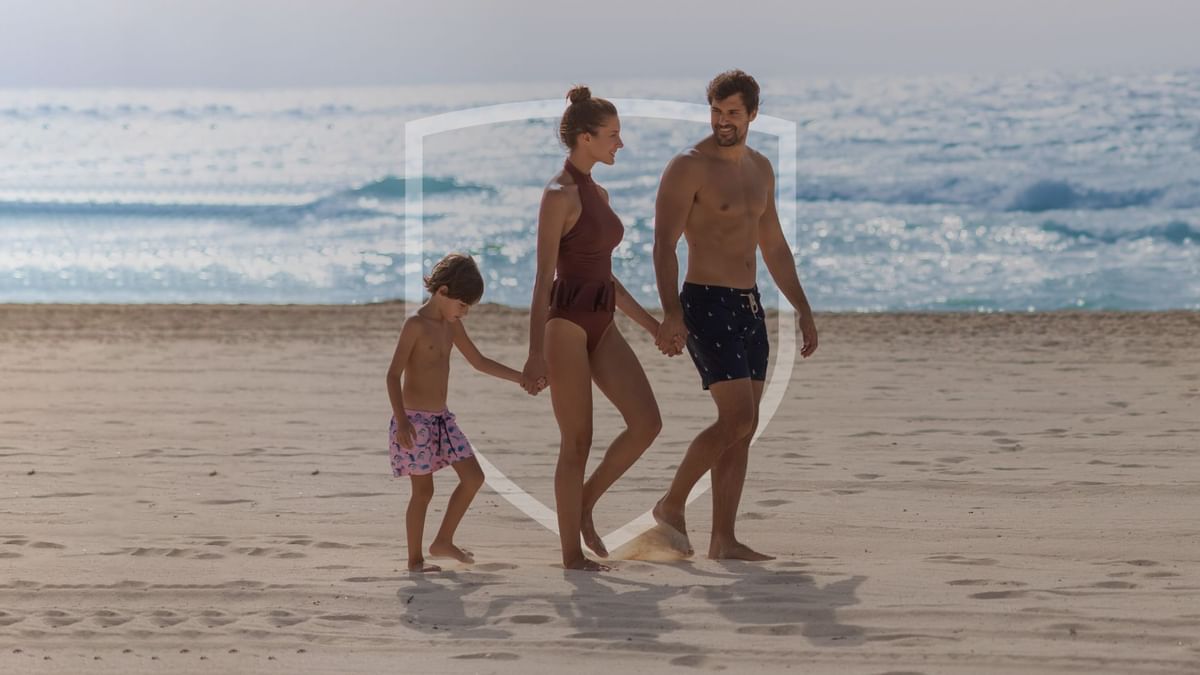 A family walking along the beach near Fiesta Inn