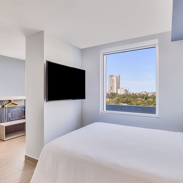 Queen bed with a TV in Accessible Room overlooking the city at One Hotels