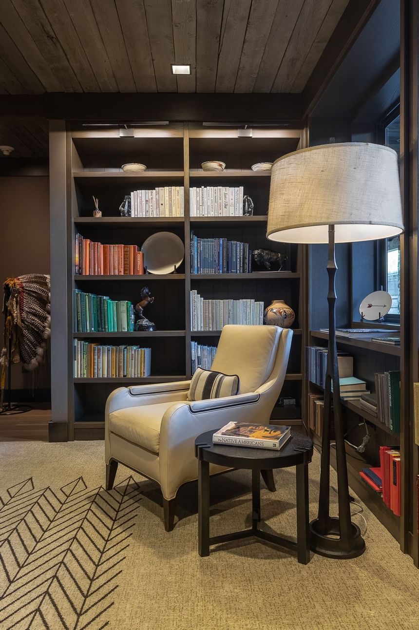 A chair near a book shelf in the Library at Hotel Jackson
