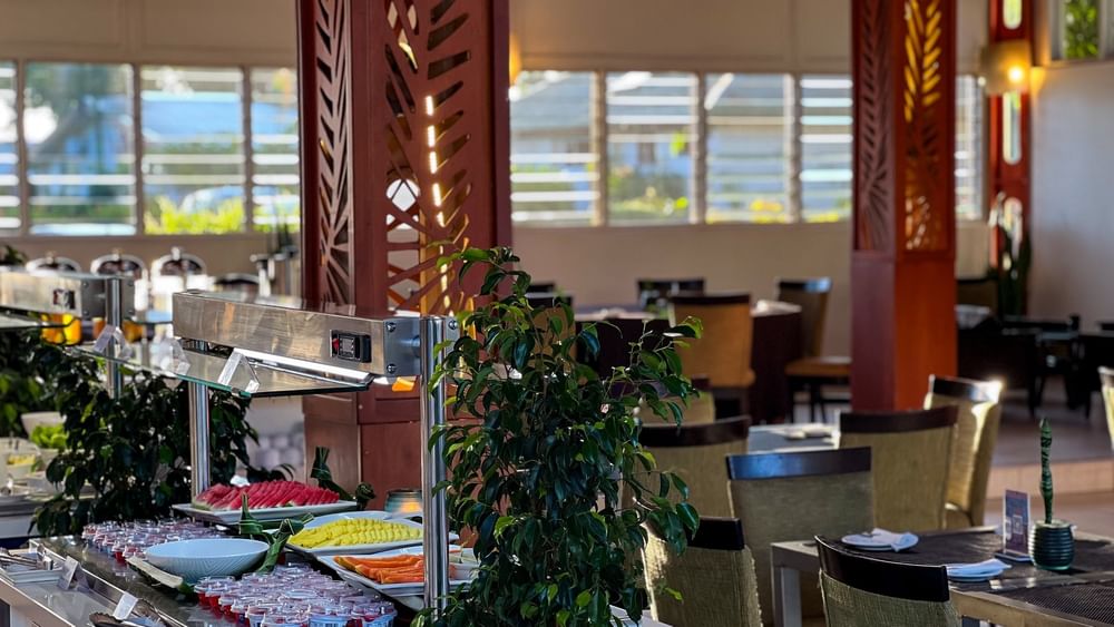 Buffet with fruits and vegetables next to dining tables at KanaVata Restaurant in Tokatoka Resort, Nadi.