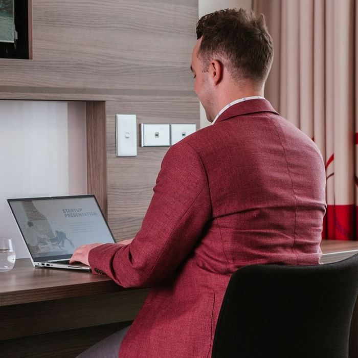 Man working on the laptop in a Room at Novotel Glen Waverley