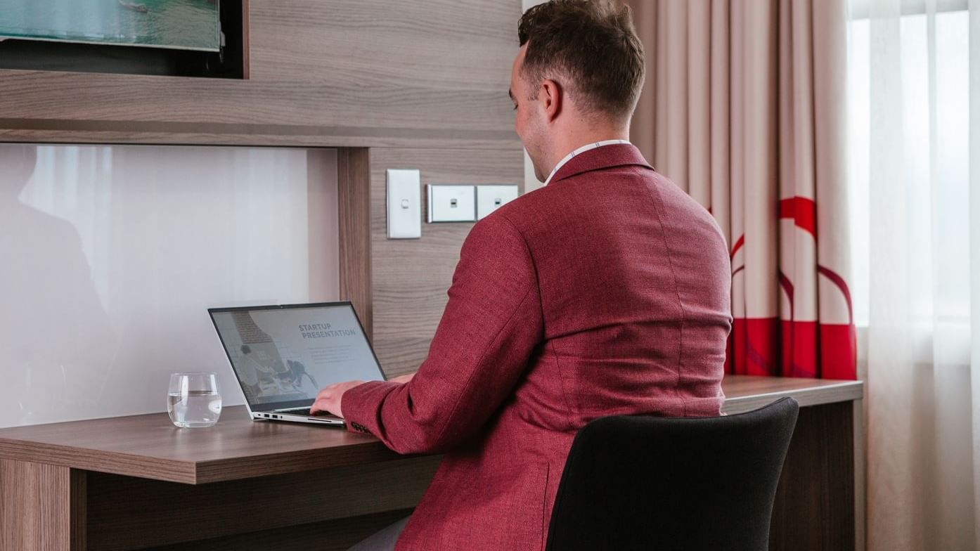 Man working on the laptop in a Room at Novotel Glen Waverley