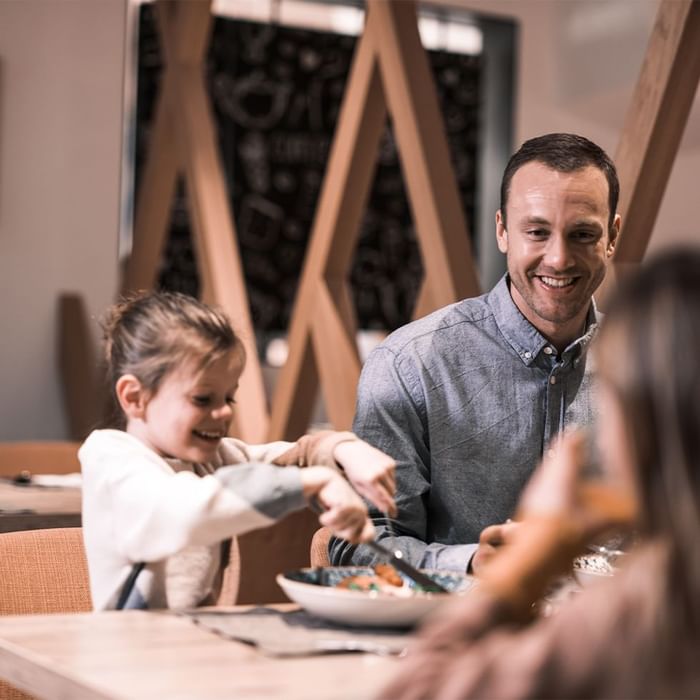 Adult and child enjoying meal in restaurant at Falkensteiner Club Funimation Katschberg