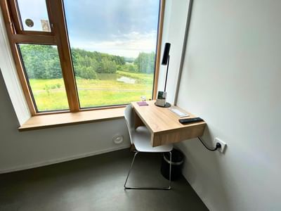 Workspace by a window with green field views in the Premium Single Room Queen Bed at Avaneo Hotel, showcasing hotel images