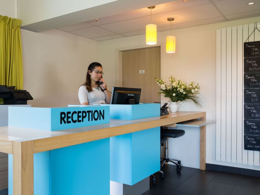 A receptionist at the reception desk in Hotel La Verriaire