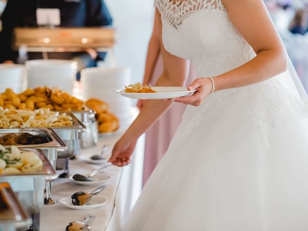 Bride serving food from the buffet in Turtle Creek at Warwick