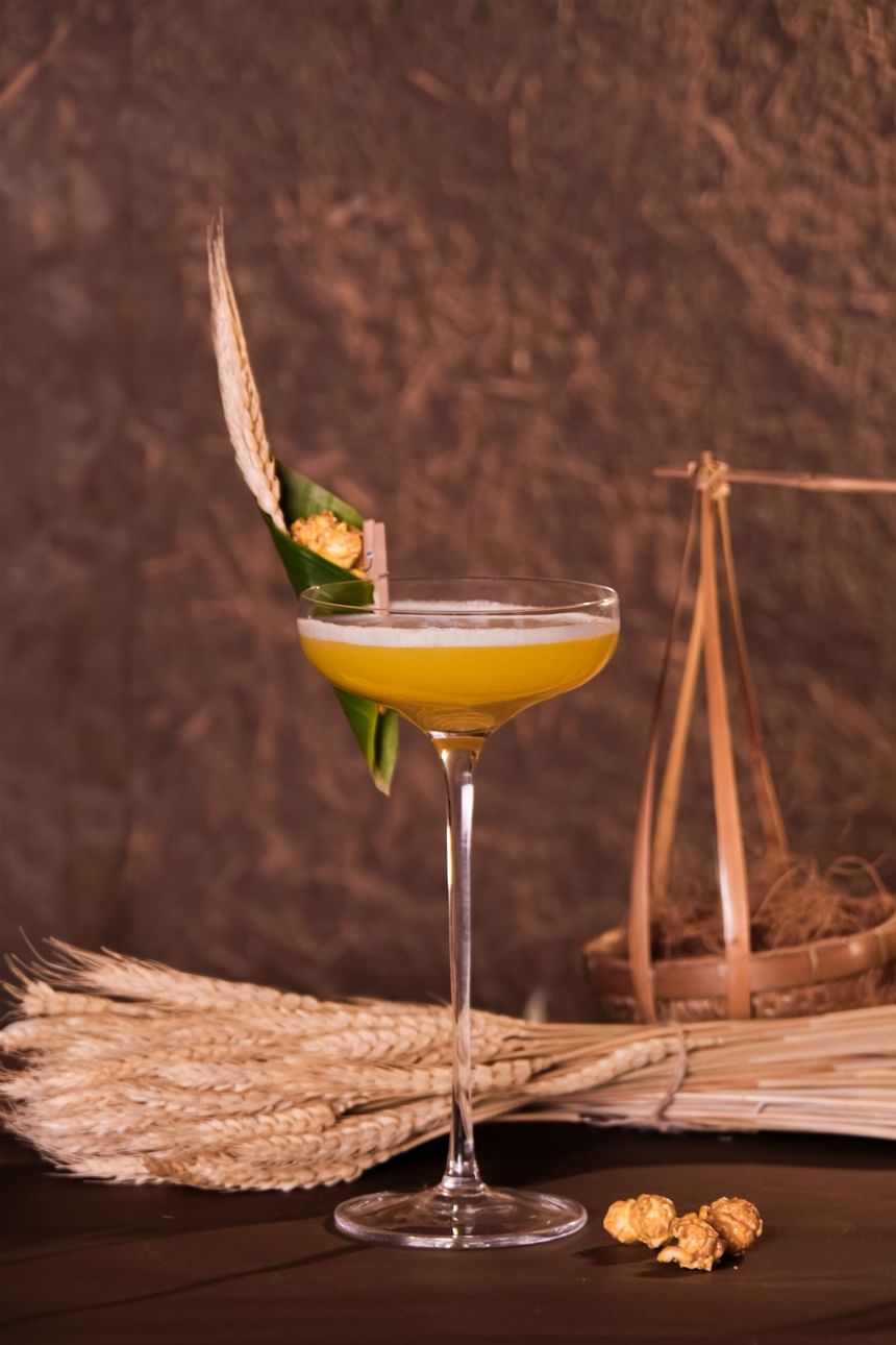 Stylish cocktail garnished with popcorn and wheat stalks in 2 Lam Son at Park Hyatt Saigon