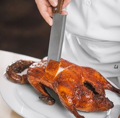 Chef slicing the baked meat skin at Hanoi Daewoo Hotel