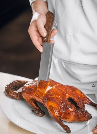 Chef slicing the baked meat skin at Hanoi Daewoo Hotel