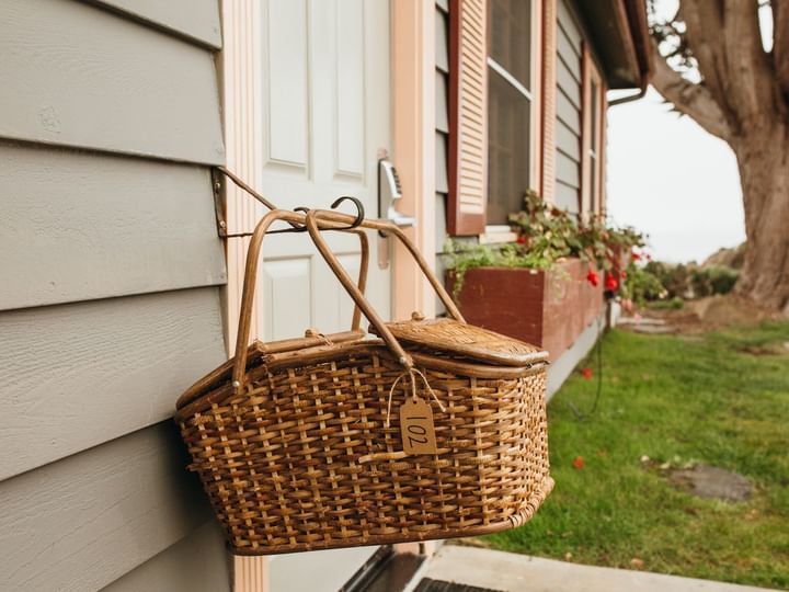 A wicker picnic basket hangs on a house door.