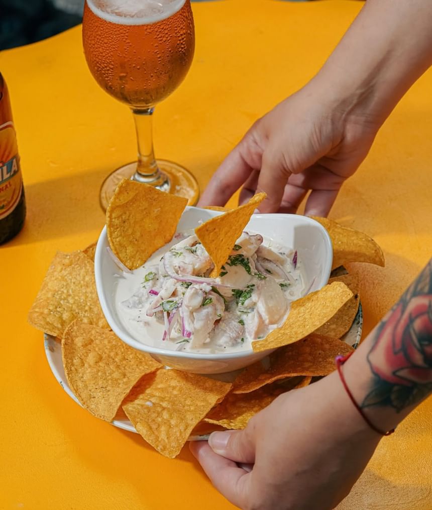 Creamy seafood ceviche served with crispy tortilla chips and a cold beer at El Nogal Restaurant in Riviera Hotel South Beach