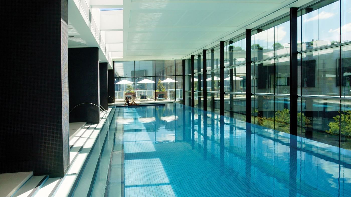 Indoor pool with lounge chairs at Crown Hotels