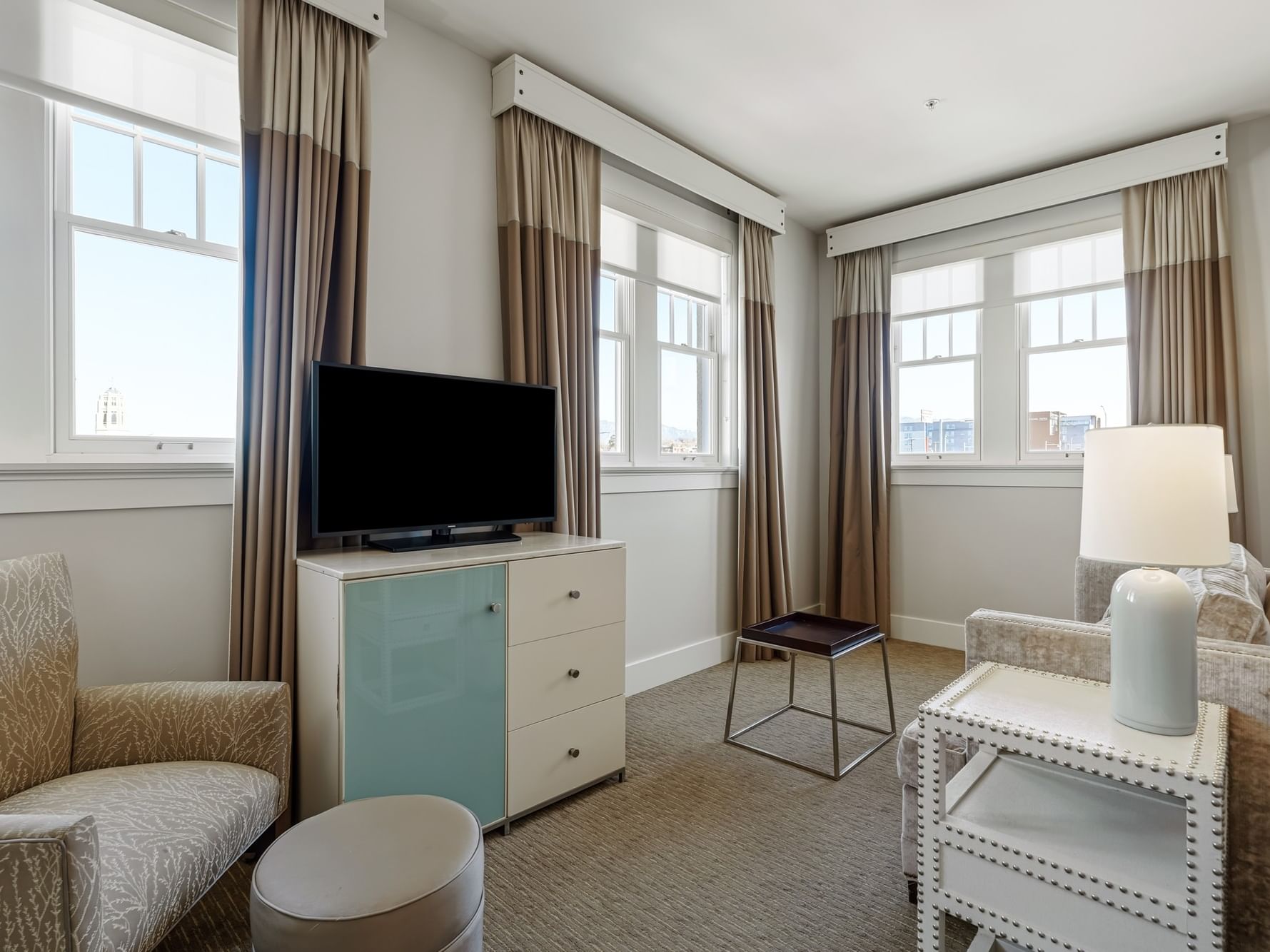 Living area with couch, chair, TV, and side table in One Bedroom Suite at Hotel Parq Central in Albuquerque.