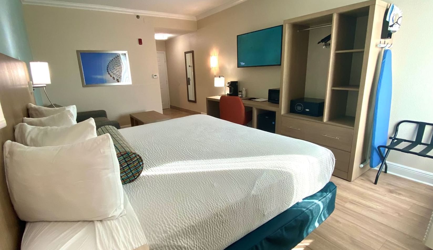 Bed by a wooden desk & wardrobe in King Room at Galleria Palms Hotel, a hotel near Disney World with free Wi-Fi & parking