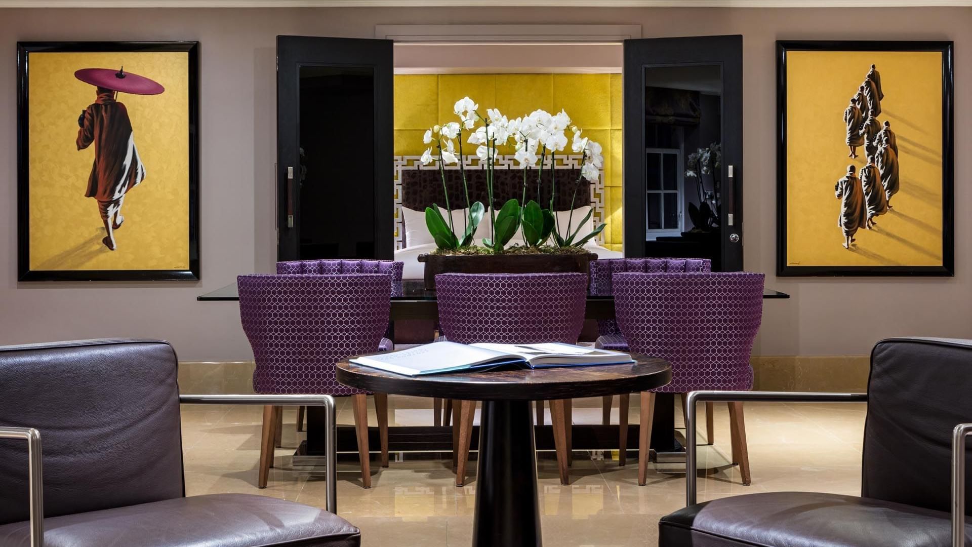 Modern lounge in The Amarillo Suite at The May Fair Hotel, London, with purple chairs, a table, and a floral centerpiece