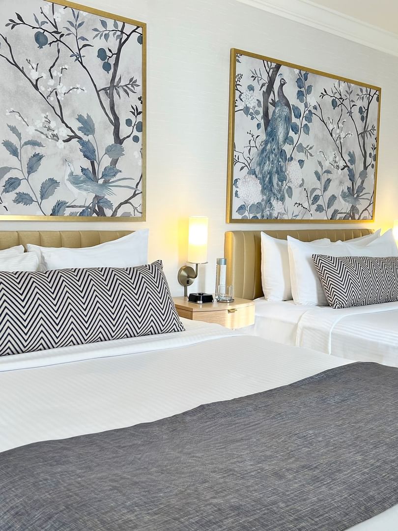 Two queen beds with white linens and blue and black patterned pillows at Warwick Allerton Chicago