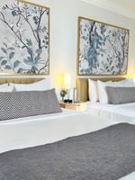 Two queen beds with white linens and blue and black patterned pillows at Warwick Allerton Chicago