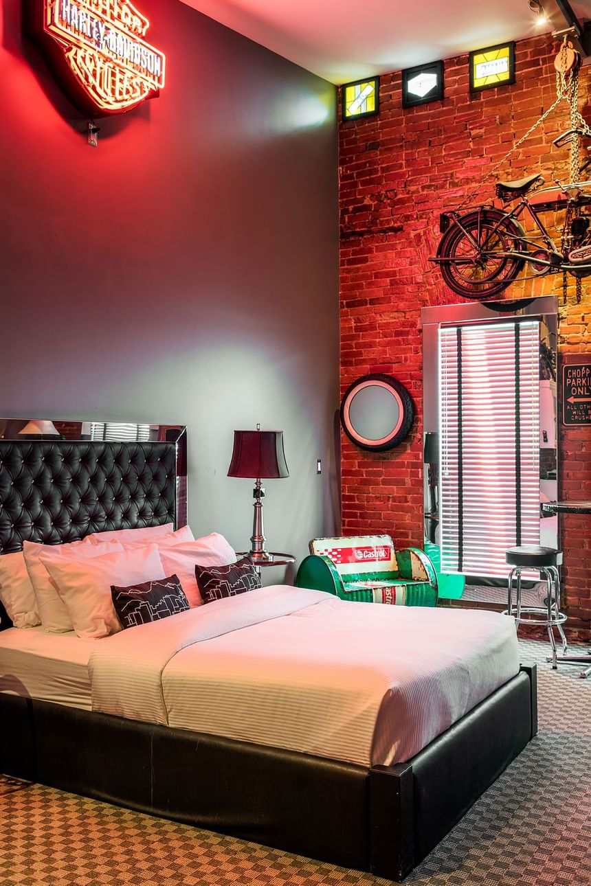 Harley Davidson neon signboard, comfy bed & vintage motorbike in Queen Premiere Easy Rider at Retro Suites Hotel