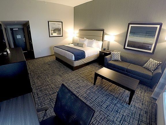 Work desk, TV, and seating area by the cozy bed in the King Sofa Room at Shangri-La Resort and Golf Club