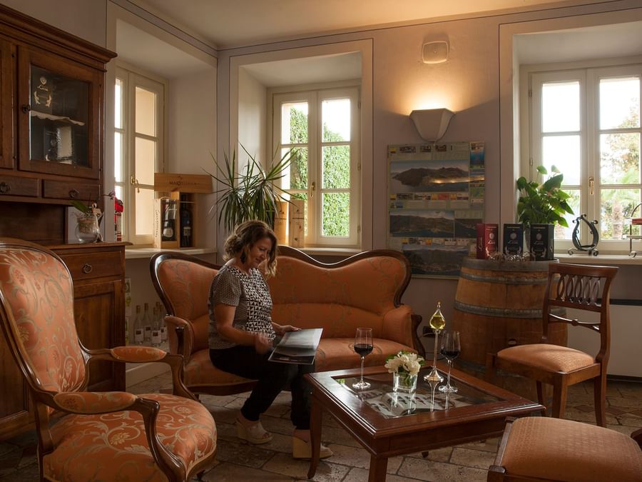 A lady seating in the living room at Villa Margherita
