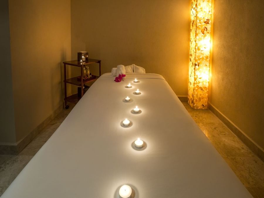 Spa bed with lit candles in a spa at FA Hotels & Resorts