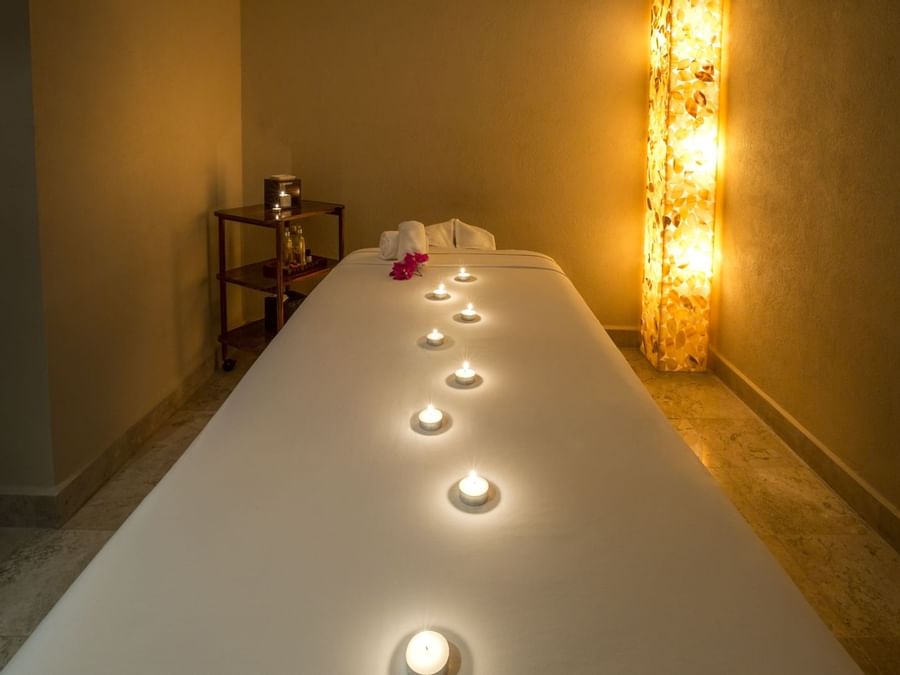 Cama de spa con velas encendidas en un spa de FA Acapulco Villas