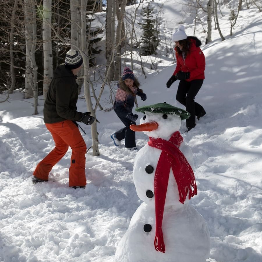 A family enjoying & building a snowman at Stein Lodge in winter
