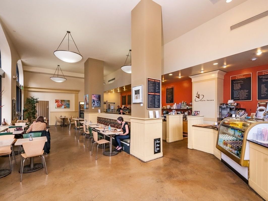 Two diners at tables with menu boards and drinks display in Pickwick San Francisco.