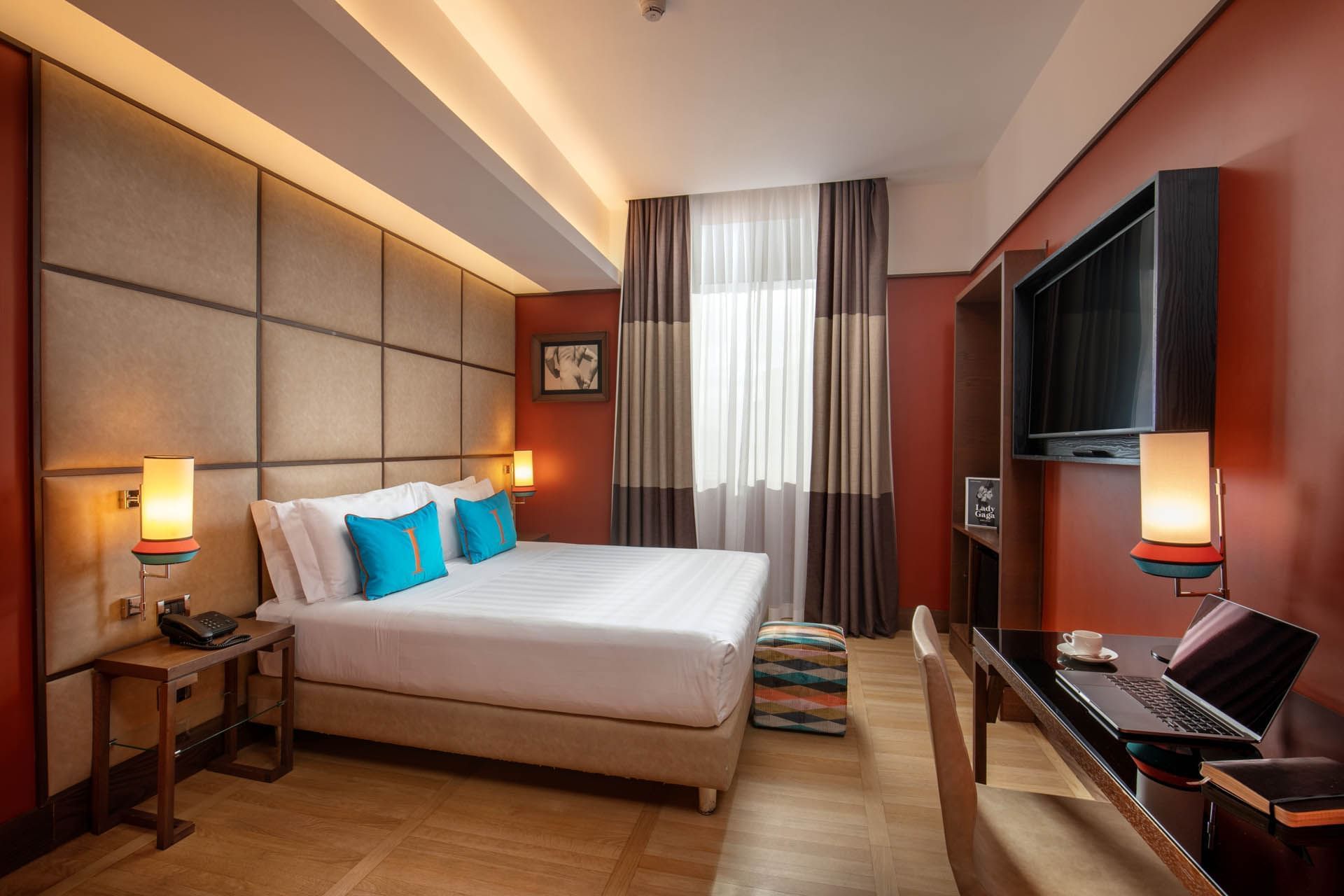 Modern Classic Room at The Independent with king bed, blue cushions, desk, and large window with curtains