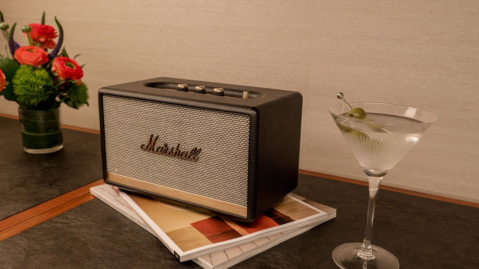 Marshall speaker, martini glass, and fresh flowers on a dark countertop in the Manhattan Suite at Gansevoort Meatpacking NYC - NEW.