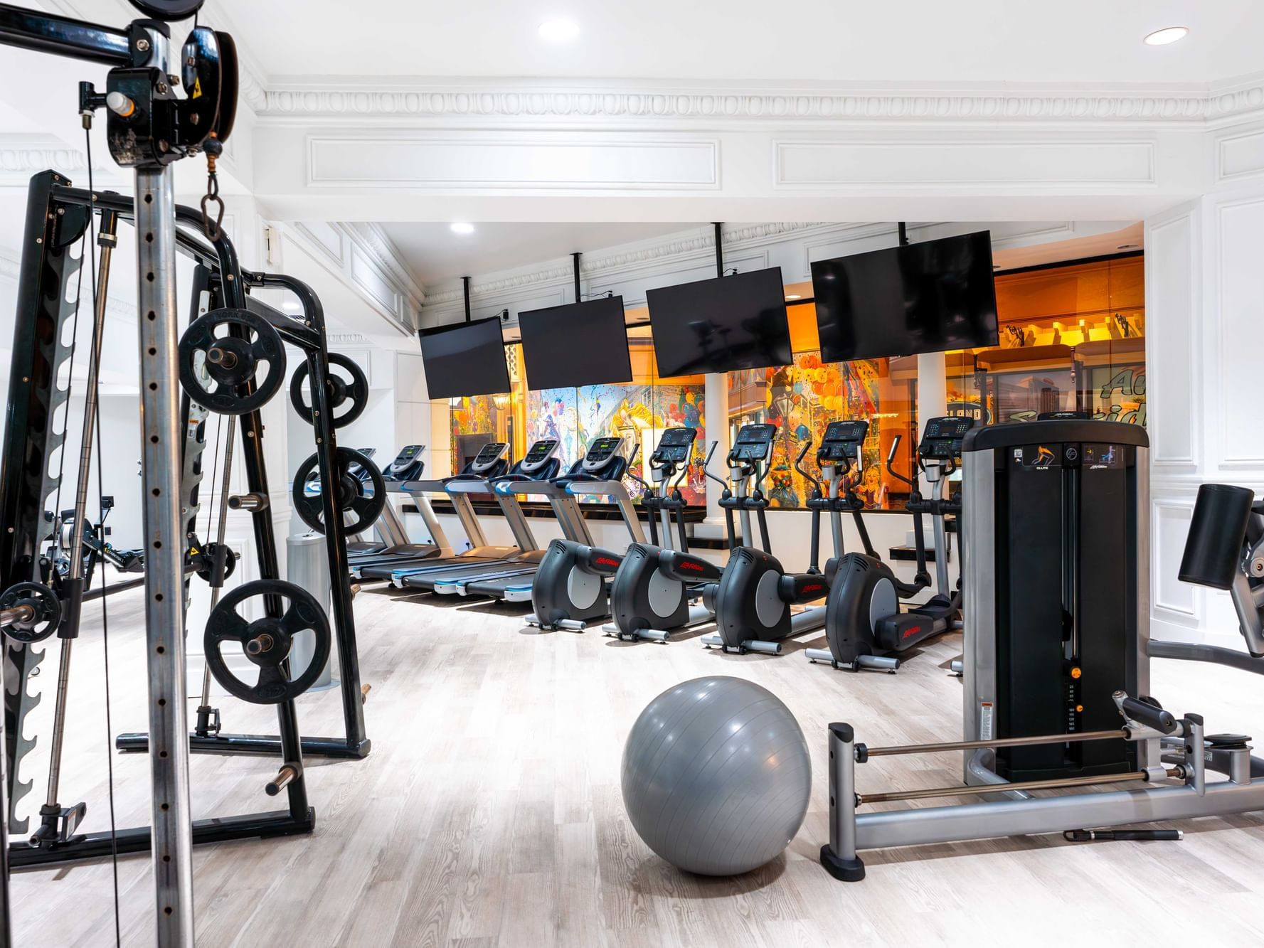 Modern gym interior with equipment, treadmills and colorful wall art at Showboat Hotel & Resort